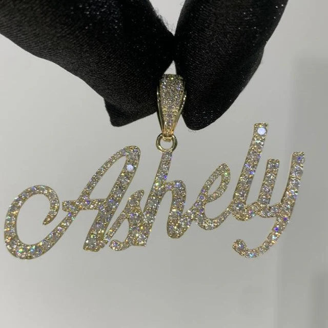 front angle photo of a Custom diamond Name pendant "ashley" being held by a black glove on a white background
