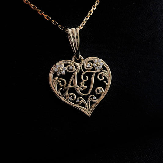 front shot of a custom initial heart pendant in 18k yellow gold, with natural VS diamonds