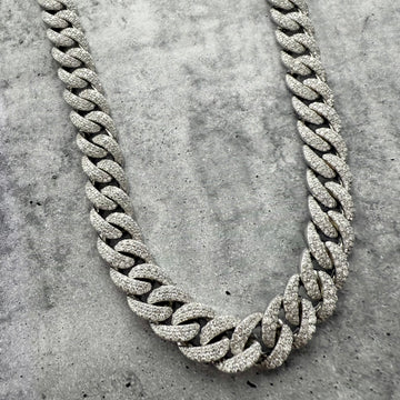 A Custom Iced out Diamond Silver chain necklace on a textured grey surface