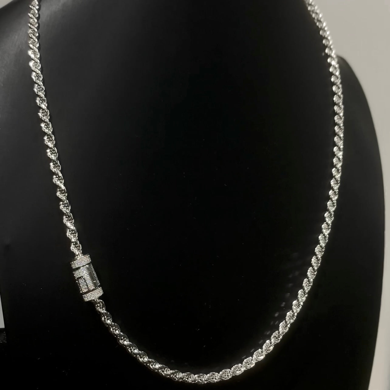 a front shot photo of a custom sterling silver rope chain with a diamond barrel clasp on a black necklace jewellery stand.