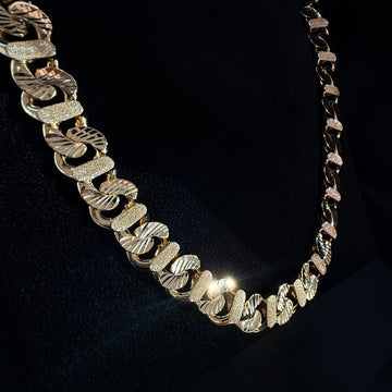 A Custom Gold Cuban chain necklace with a sandblasted and Diamond Cut finish on a black background