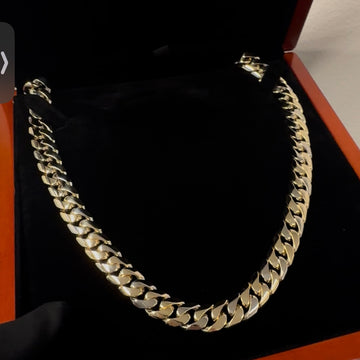 Gold chain necklace on a black background in a box