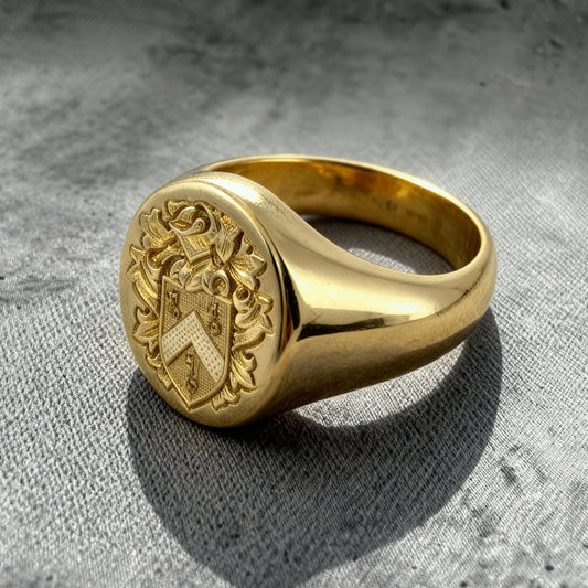 Custom Signet Ring Family crest, Gold ring with a detailed emblem on a textured gray surface