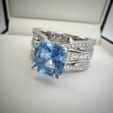 a close up shot of a 18k White gold Ring with a natural aquamarine gemstone, with accent diamonds.